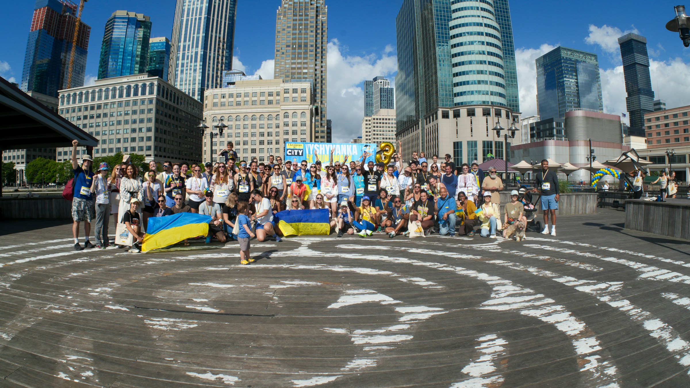 Large group of supporters gathered with flags at a city fundraising event