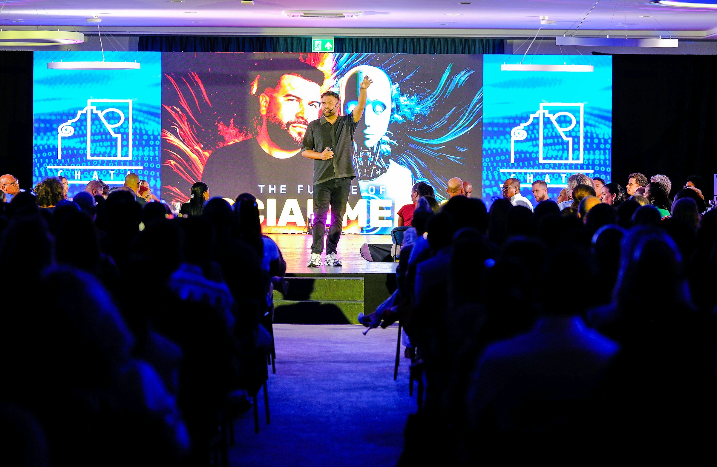 Speaker presenting on a brightly lit stage at a launch event