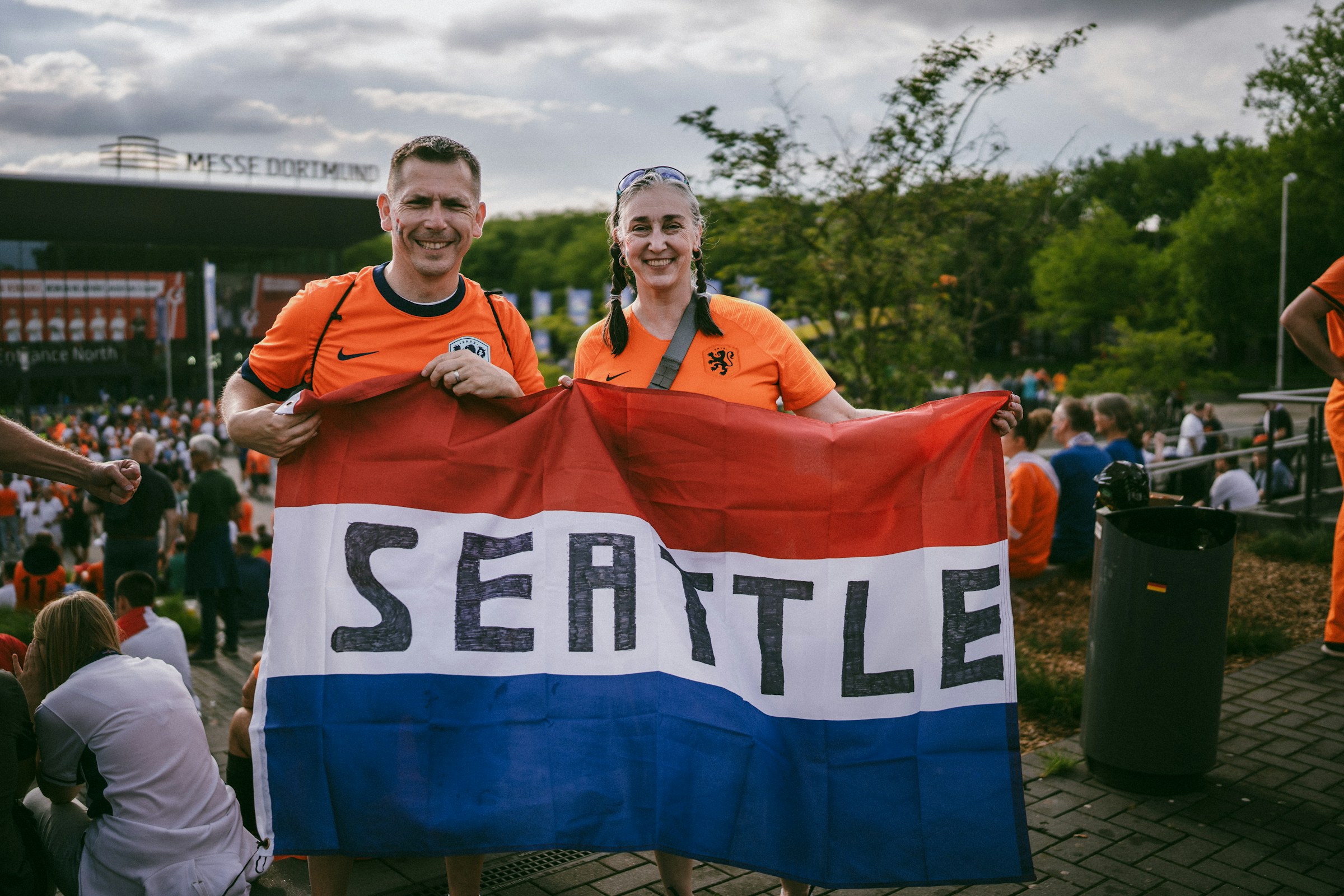 Supporters holding a flag at an outdoor branded sports event
