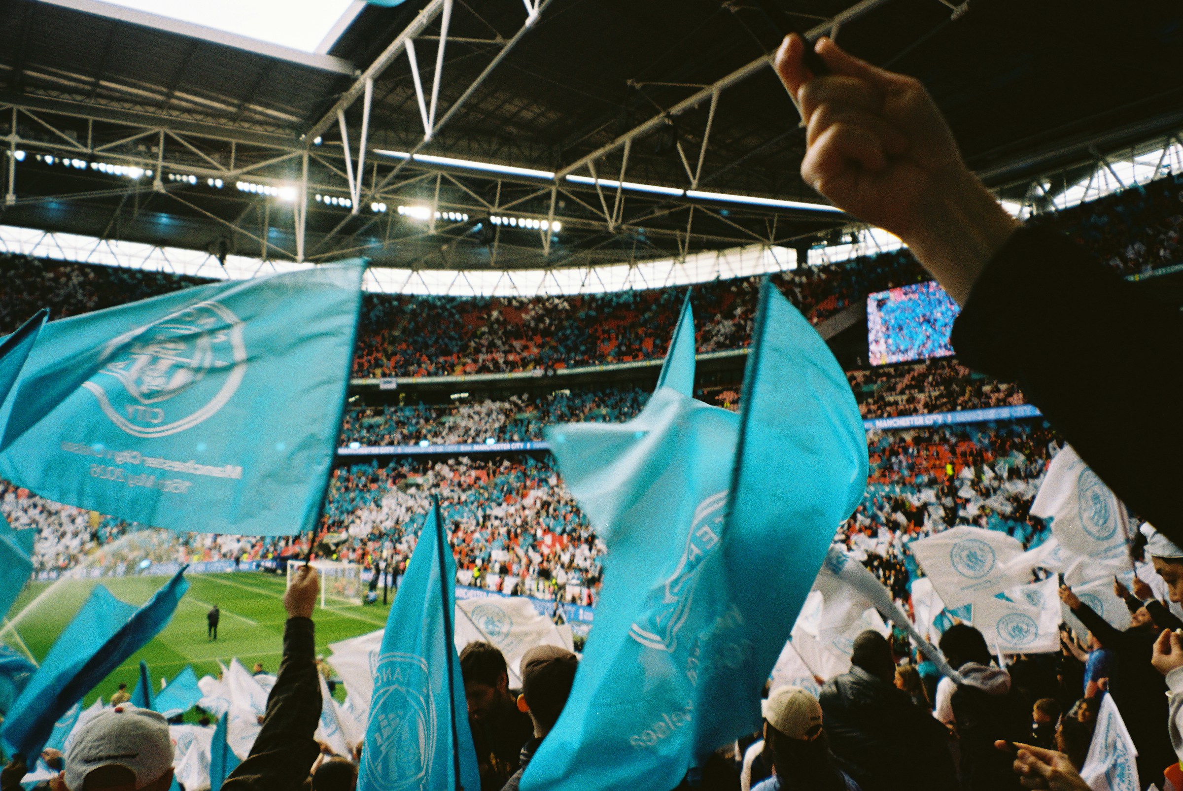 Fans waving flags in a packed stadium during a match